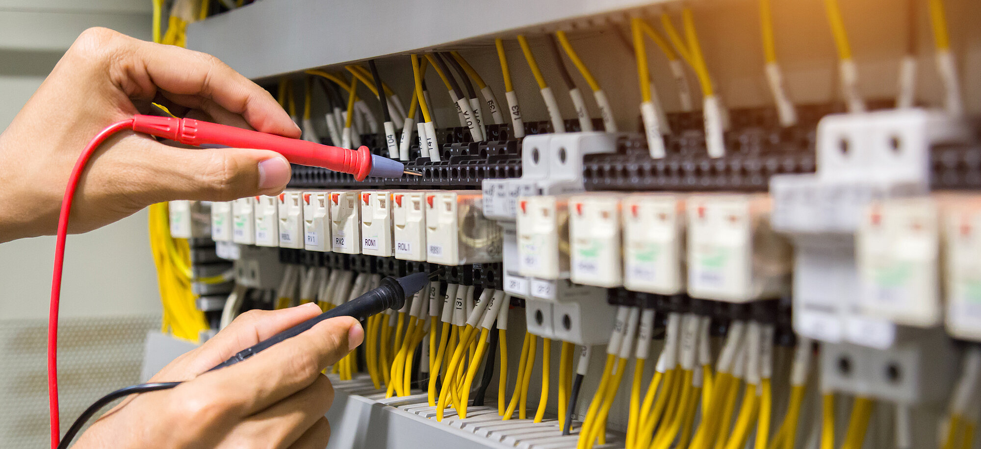 Elektriker prüfen den Strom im Schaltschrank.